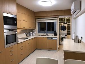 a large kitchen with wooden cabinets and appliances at Kennedy Deluxe Suites in Nicosia