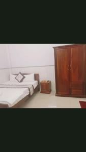 1 dormitorio con 1 cama y armario de madera en Minh Minh Hotel, en Quy Nhon