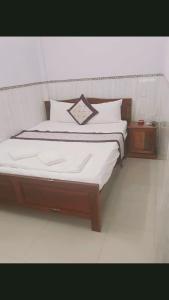 un letto con lenzuola e cuscini bianchi in una stanza di Minh Minh Hotel a Quy Nhon