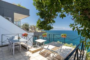 a balcony with a table and chairs and the ocean at Vero Sicily - Villa Acqua Chiara in Bagheria