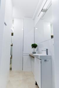 a kitchen with white walls and a sink at M&K Apartamenty - Morska Bryza, Sobieszewo- Wyspa Sobieszewwska in Gdańsk +24 photos
