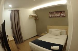 Postel nebo postele na pokoji v ubytování 1 Orange Hotel Sungai Buloh
