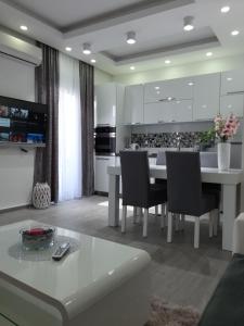 cocina con mesa blanca y sillas en Apartments Pepdjonovic, en Ulcinj