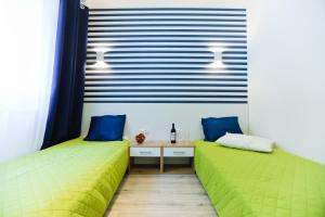 two beds in a room with blue and green at M&K Apartamenty - Morska Bryza, Sobieszewo- Wyspa Sobieszewwska in Gdańsk
