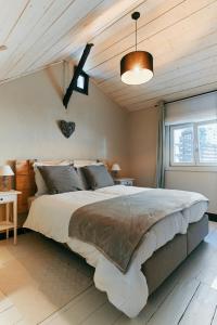 a bedroom with a large bed and a wooden ceiling at Le Petit Gretedar in Malmedy