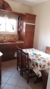a kitchen with a table with a flowered table cloth at Pitsinis Apartments II in Roda +13 photos