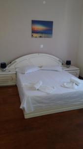 een slaapkamer met een wit bed met twee handdoeken erop bij Pitsinis Apartments II in Roda +13 foto's