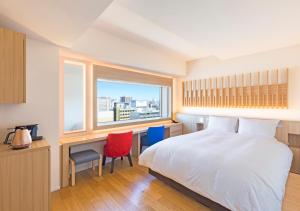 a bedroom with a bed and a desk and a window at HOTEL＆SPA CENTURY MARINA HAKODATE in Hakodate