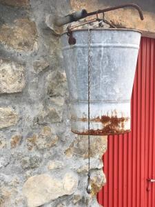 a metal bucket hanging from a stone wall at Quinta Bogesi in Figueira da Foz