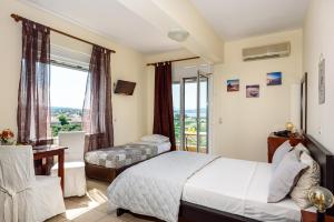 a hotel room with a bed and a window at Golden Beach Hill Apartments in Kato Daratso