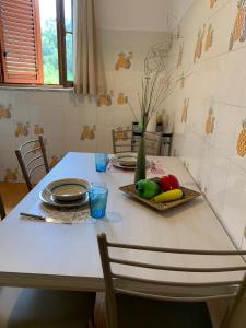 a white table with plates and fruits on it at Acquamarina in Gaeta
