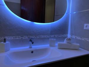 a bathroom with a white sink with a blue light at Acquamarina in Gaeta