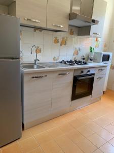 a kitchen with a sink and a stainless steel refrigerator at Acquamarina in Gaeta