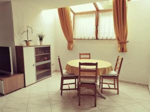 d'une salle à manger avec une table, des chaises et une fenêtre. dans l'établissement Ferienwohnung Jasmin & Alex, à Mühlhausen-Ehingen