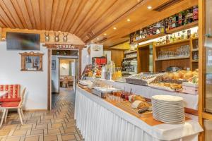 a bakery with a counter with plates and food at Hotel Edda in Selva di Val Gardena