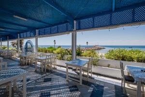 a patio with tables and chairs and the ocean at Hotel Cercina in Ouled Yaneg