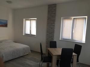 Schlafzimmer mit einem Bett, einem Tisch und Stühlen in der Unterkunft Apartment Goreta in Trogir