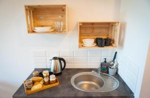 a kitchen counter with a sink and wooden cabinets at Villa Brody in Wisła
