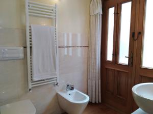 ein Badezimmer mit einem Waschbecken, einem WC und einem Spiegel in der Unterkunft Bed and Breakfast Isabella in Miane