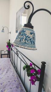 una lámpara azul y blanca colgada sobre una cama en Le 7 sorelle, en Lipari