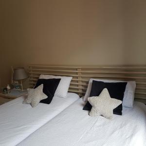 two beds with black and white pillows in a bedroom at La casa de Maria in San Sebasti&aacute;n