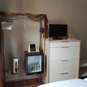 een slaapkamer met een tv en een dressoir met een televisie bij La casa de Maria in San Sebastian