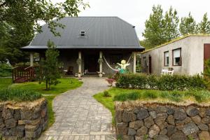 una casa con un camino de piedra delante de ella en Varmi Guesthouse Apartments & rooms en Hveragerði