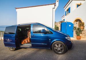 a blue van parked in a parking lot at Castri Village Kythira Quality Resort in Agia Pelagia