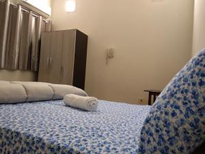 a bed with a towel laying on top of it at Hotel Catedral in Ciudad del Este