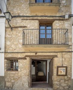 un edificio in pietra con porta e balcone di Alojamiento Rural Font del Roser a Chiva de Morella