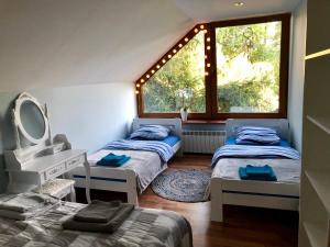 a bedroom with two beds and a mirror and a window at OSTOJA BONDYRZ in AdamÃ³w