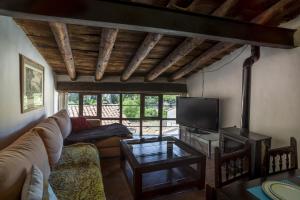 a living room with a couch and a tv at Alojamiento Rural Font del Roser in Chiva de Morella
