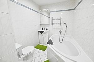 La salle de bains blanche est pourvue de toilettes et d'une baignoire. dans l'établissement apartmány 2+1 u Klínovce, à Kovářská