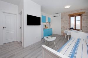 a living room with a tv on a wall at Apartment Babbo in Rovinj