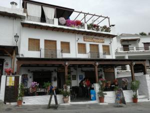 a building with flowers on the top of it at Hostal Moraima in Capileira