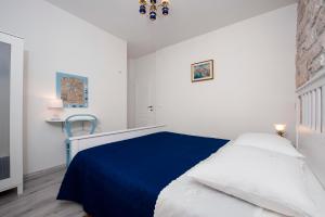 a bedroom with a blue and white bed and a chair at Apartment Babbo in Rovinj