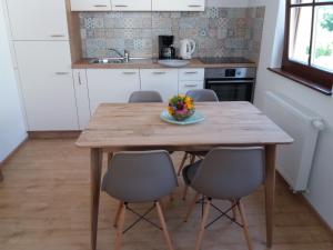 uma mesa de madeira numa cozinha com cadeiras à volta em Nono Marjo em Bovec