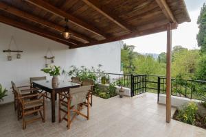 een patio met een tafel en stoelen en een balkon bij Diogenis Residence Euphoria in Arménoi