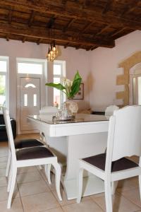 uma sala de jantar com uma mesa branca e cadeiras em Diogenis Residence Euphoria em Arménoi