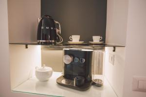 een koffiezetapparaat op een plank met kopjes erop bij Suites of the Royal Council in Siracusa