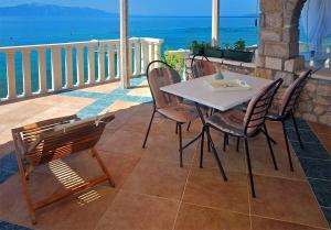 a table and chairs on a balcony with the ocean at Apartments Martina Brist in Brist