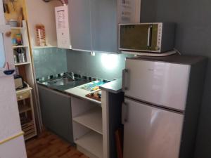 eine Küche mit einem Kühlschrank und einer Mikrowelle in der Unterkunft studio Cap D'adge in Cap d'Agde