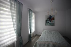 a bedroom with a bed and a window with blinds at Apartament wygodny S3 in Kalisz