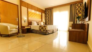 ジブチにあるAtlantic Hotelのベッドと椅子付きのホテルルーム