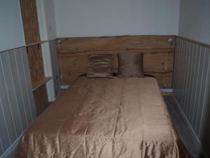 a bed with a wooden headboard in a bedroom at La Maison de l'Ormeau in Montauban