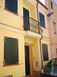 budynek z balkonem i samochód zaparkowany obok niego w obiekcie CASA PUTIFIGARI w mieście Putifigari