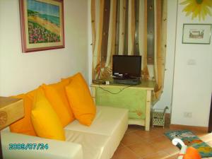 a living room with a white couch with orange pillows at CASA PUTIFIGARI in Putifigari