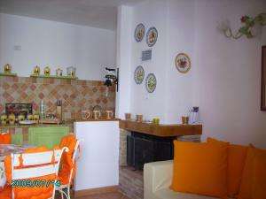a living room with a couch and a kitchen with plates on the wall at CASA PUTIFIGARI in Putifigari