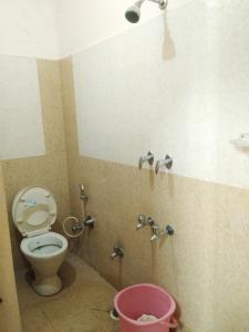 a bathroom with a toilet and a pink bucket at COMFORT INN in Nāmakkal