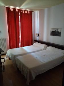 サントマリー・ド・ラメールにあるAuberge MAS DE LAYALLEのベッド2台 ホテルルーム 赤いカーテン付